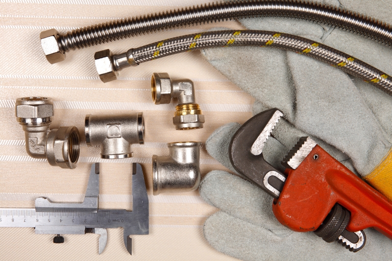 Plumber working on pipes in a Brent Cross home